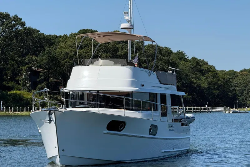  Yacht Photos Pics 2018 Beneteau Swift Trawler 44 cruising on a serene lake with lush greenery.