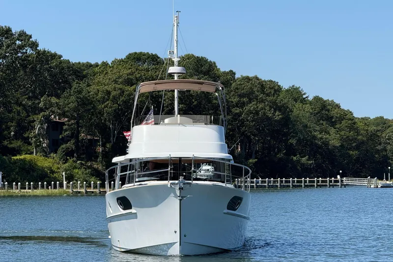  Yacht Photos Pics 2018 Beneteau Swift Trawler 44 cruising on a serene lake with forested backdrop.