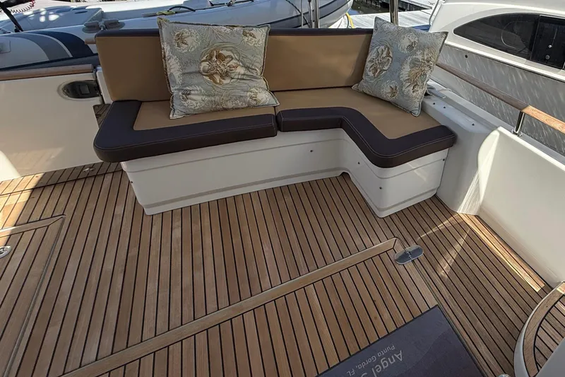 Yacht Photos Pics 2018 Beneteau Swift Trawler 44 interior with cushioned seating and wooden flooring.