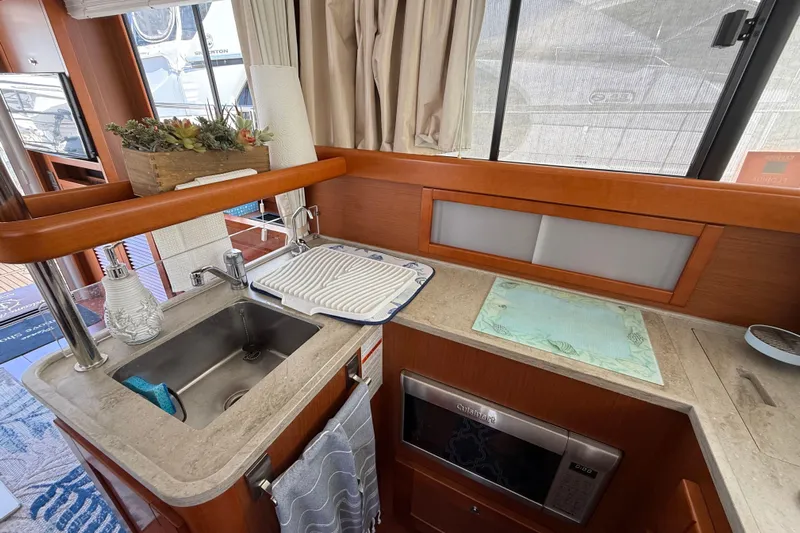  Yacht Photos Pics 2018 Beneteau Swift Trawler 44 kitchen with sink, microwave, and countertop decor.