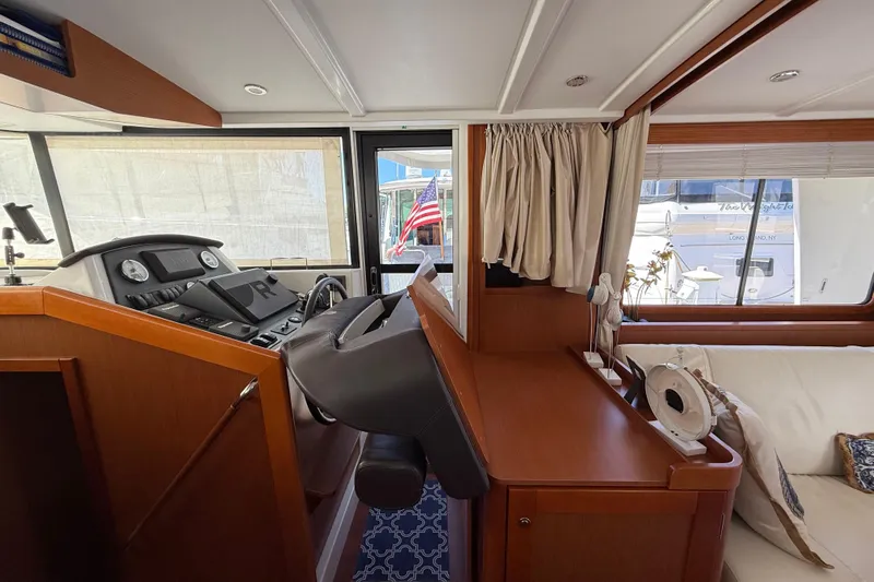  Yacht Photos Pics Interior of 2018 Beneteau Swift Trawler 44 with helm station and seating area.