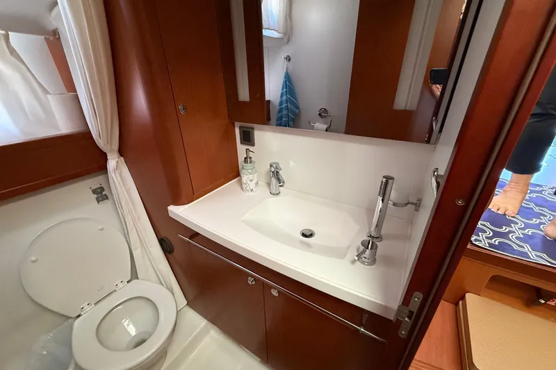  Yacht Photos Pics 2018 Beneteau Swift Trawler 44 bathroom with sink, toilet, and wooden cabinetry.