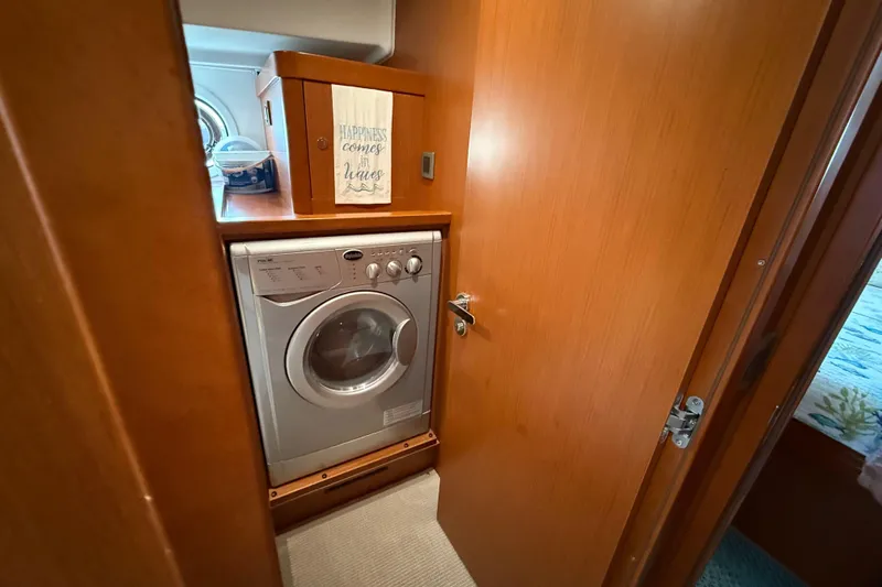  Yacht Photos Pics Laundry area inside 2018 Beneteau Swift Trawler 44, featuring a compact washing machine.