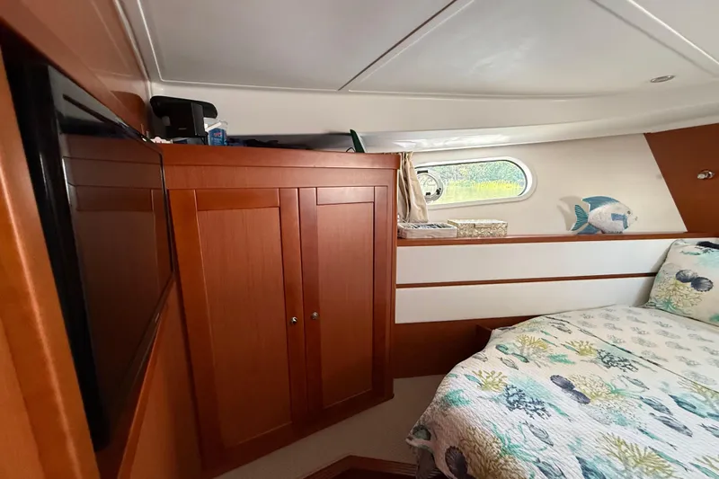  Yacht Photos Pics 2018 Beneteau Swift Trawler 44 cabin interior with wood cabinetry and nautical-themed bedding.