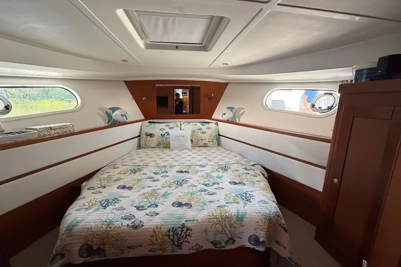  Yacht Photos Pics Cozy bedroom in 2018 Beneteau Swift Trawler 44 with nautical-themed decor.