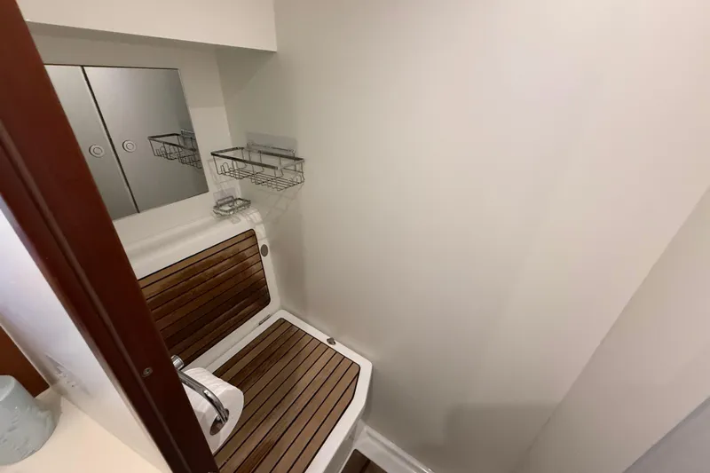  Yacht Photos Pics Bathroom interior of 2018 Beneteau Swift Trawler 44 with wooden accents and storage shelves.