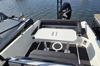 2022 Iron 827 T-Top boat interior with seating and table, docked by the water.