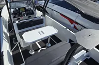 2022 Iron 827 T-Top boat interior with seating and table, docked beside another boat.