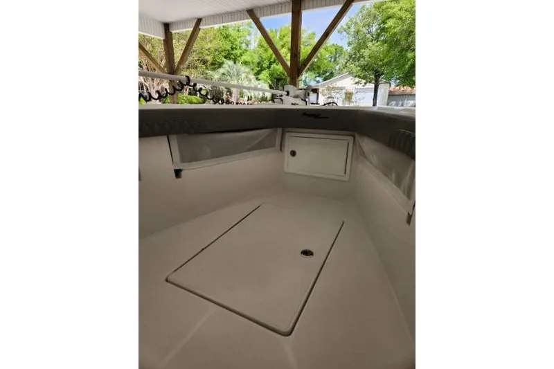  Yacht Photos Pics 2023 Front Runner 36 cc boat interior under a canopy with lush greenery.