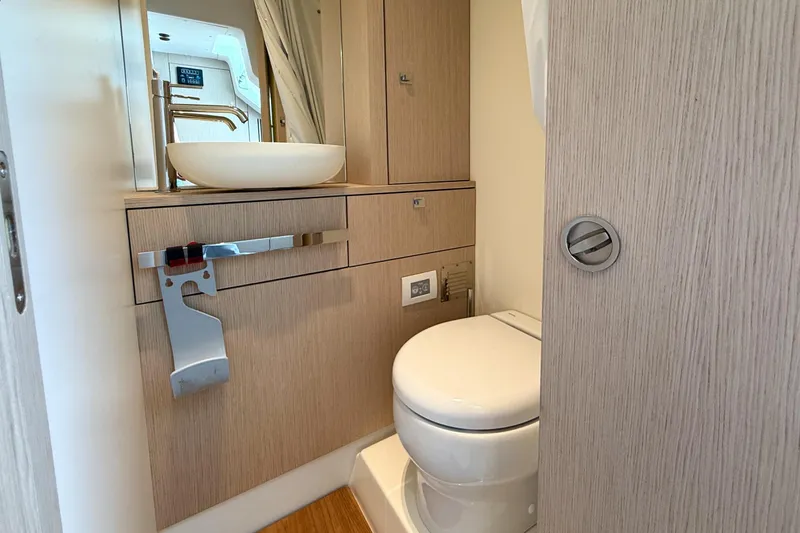 Amy Yacht Photos Pics 2023 Cranchi Sessantasette 67 yacht bathroom with modern fixtures and light wood cabinetry.