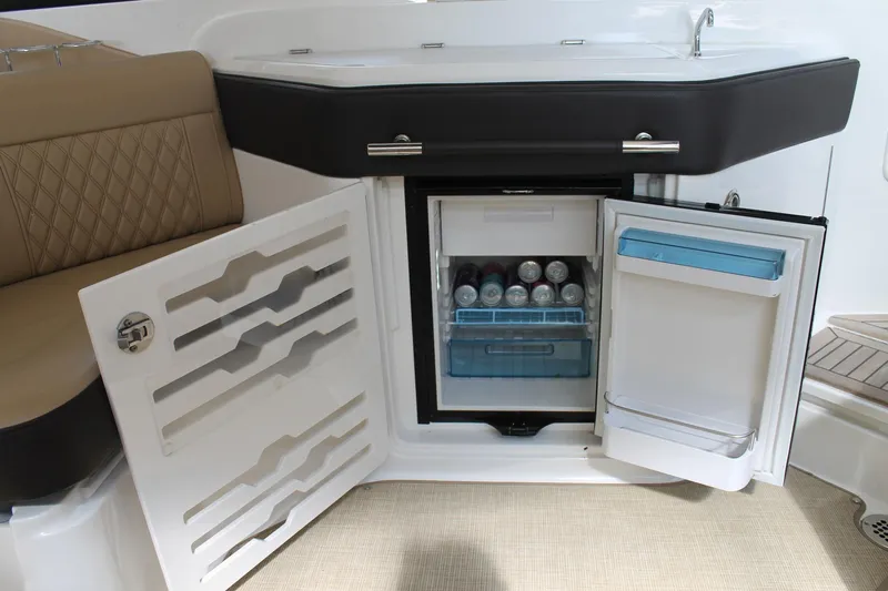  Yacht Photos Pics 2023 Sea Ray SLX 310 Outboard boat interior with open mini fridge and seating area.