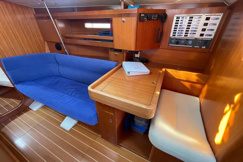 Jaacktak Yacht Photos Pics Interior of 2004 Dufour 40 Performance yacht with blue sofa and navigation station.