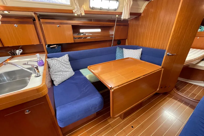 Jaacktak Yacht Photos Pics Cozy interior of 2004 Dufour 40 Performance yacht with blue seating and wooden table.
