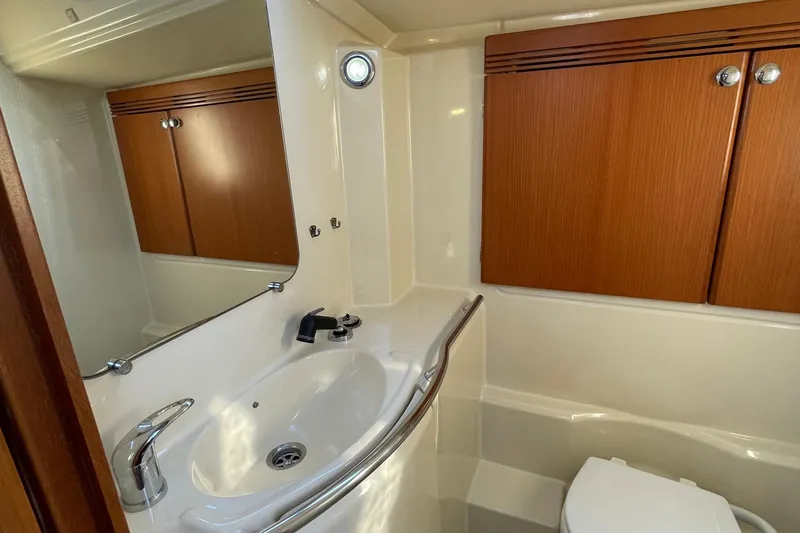 Jaacktak Yacht Photos Pics Bathroom interior of 2004 Dufour 40 Performance yacht with sink and wooden cabinets.