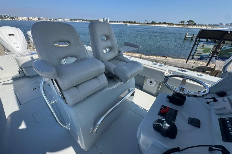 Free Spear It Yacht Photos Pics 2016 Contender 35 ST boat cockpit with dual seats and steering wheel, overlooking waterfront.