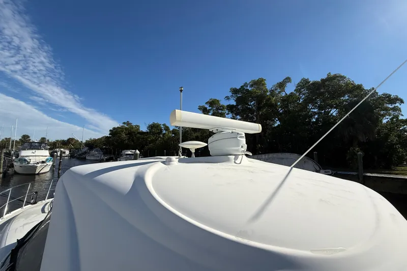  Yacht Photos Pics 2005 Sea Ray 390 Sundancer yacht with radar, docked near trees and other boats.