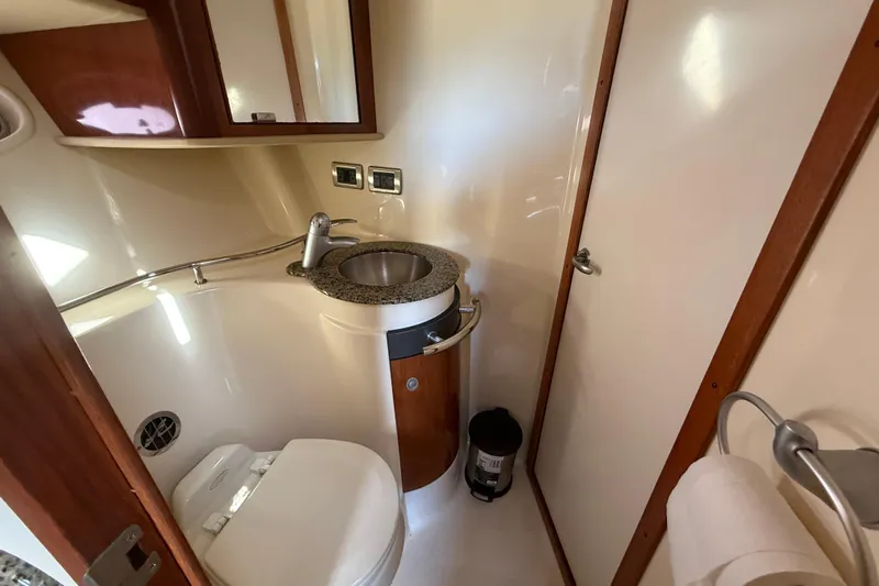  Yacht Photos Pics 2005 Sea Ray 390 Sundancer bathroom with sink, toilet, and wooden accents.