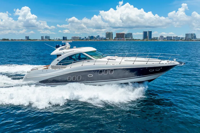 Brinee Yacht Photos Pics 2008 Sea Ray 60 Sundancer yacht cruising on blue ocean with city skyline background.