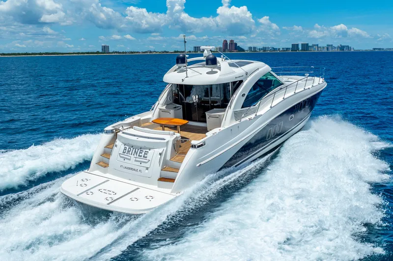 Brinee Yacht Photos Pics 2008 Sea Ray 60 Sundancer yacht cruising on blue ocean near city skyline.