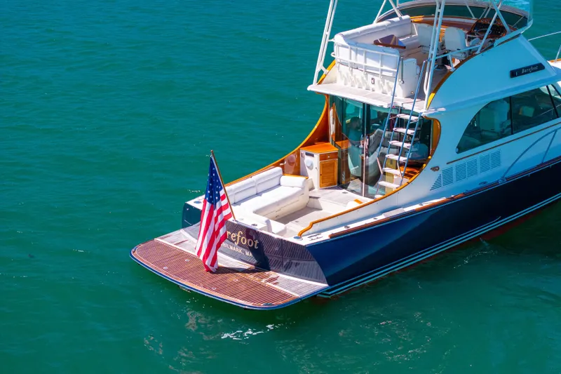Barefoot Yacht Photos Pics 2014 Hinckley Talaria 48 Flybridge yacht on clear blue water with American flag.