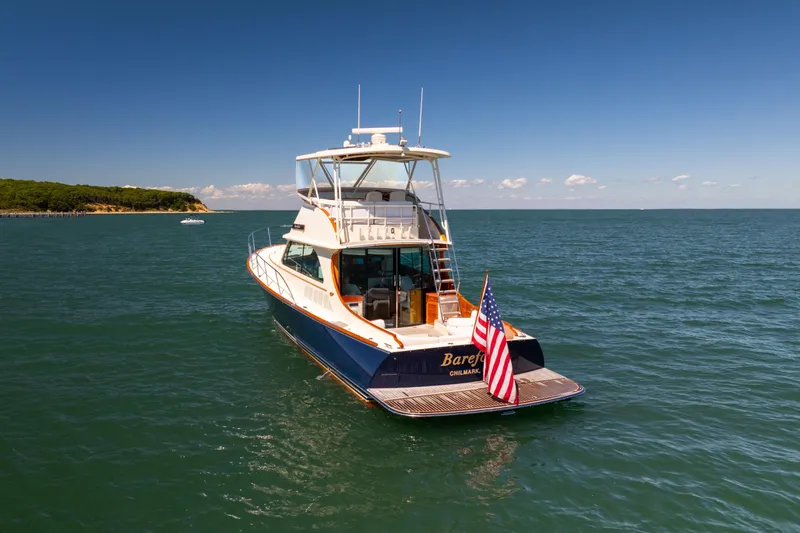 Barefoot Yacht Photos Pics 2014 Hinckley Talaria 48 Flybridge yacht on open water, American flag displayed.