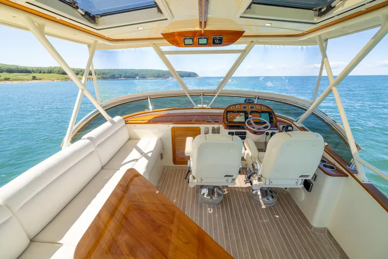 Barefoot Yacht Photos Pics 2014 Hinckley Talaria 48 Flybridge interior with ocean view, featuring helm and seating area.