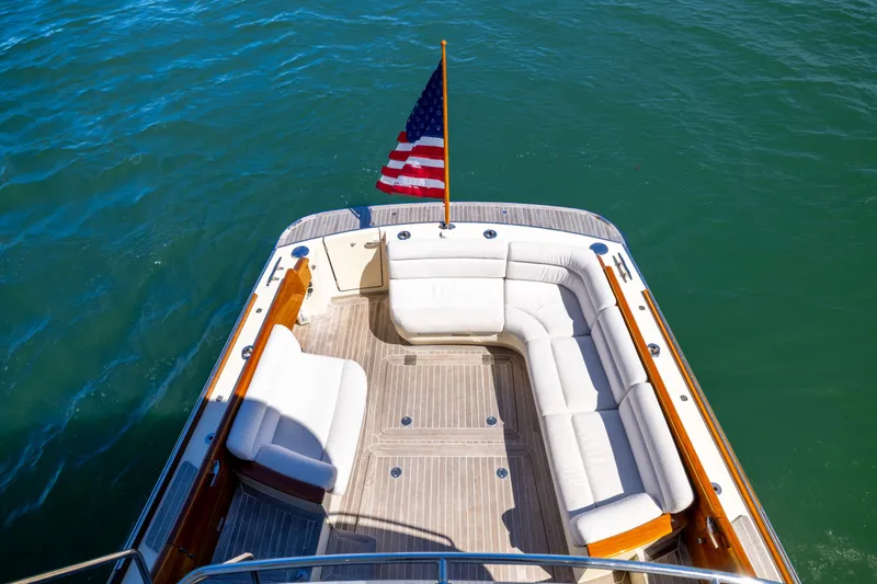 Barefoot Yacht Photos Pics Hinckley Talaria 48 Flybridge 2014 yacht with white seating and American flag on deck.