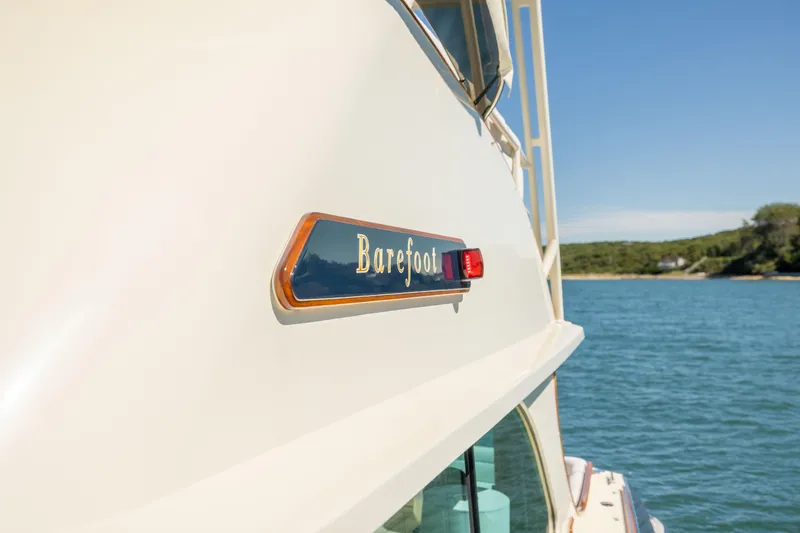 Barefoot Yacht Photos Pics 2014 Hinckley Talaria 48 Flybridge yacht on water, featuring "Barefoot" nameplate.