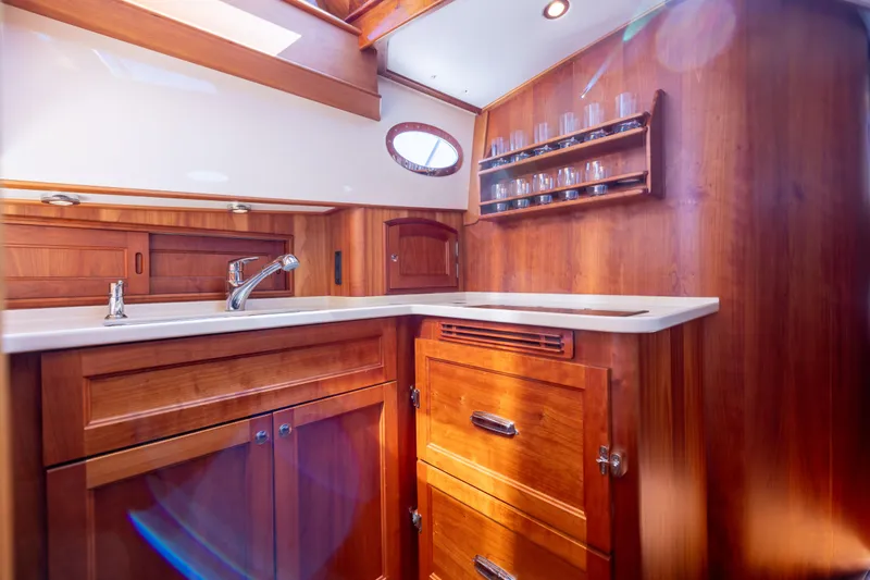 Barefoot Yacht Photos Pics Luxurious wooden interior of 2014 Hinckley Talaria 48 Flybridge yacht kitchen.