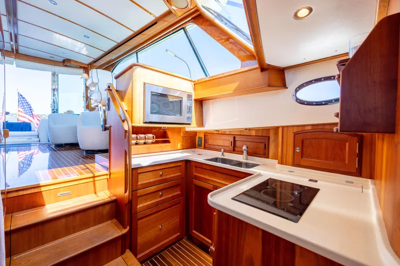 Barefoot Yacht Photos Pics Luxurious 2014 Hinckley Talaria 48 Flybridge yacht interior with modern kitchen and wooden cabinetry.