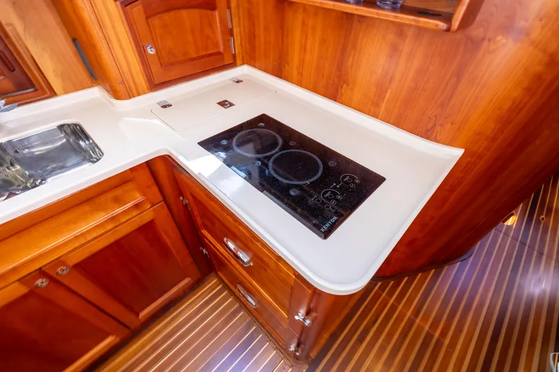 Barefoot Yacht Photos Pics Hinckley Talaria 48 Flybridge 2014 yacht kitchen with stove and wooden cabinetry.