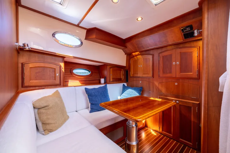 Barefoot Yacht Photos Pics Luxurious interior of 2014 Hinckley Talaria 48 Flybridge with wood cabinetry and plush seating.