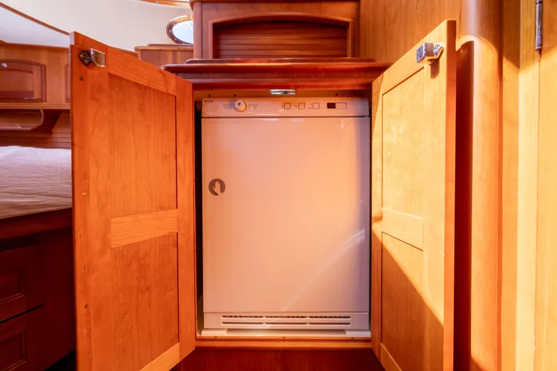 Barefoot Yacht Photos Pics 2014 Hinckley Talaria 48 Flybridge interior with built-in dishwasher in wooden cabinetry.