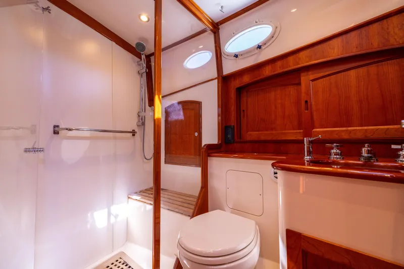 Barefoot Yacht Photos Pics Luxurious 2014 Hinckley Talaria 48 Flybridge bathroom with wood accents and modern fixtures.