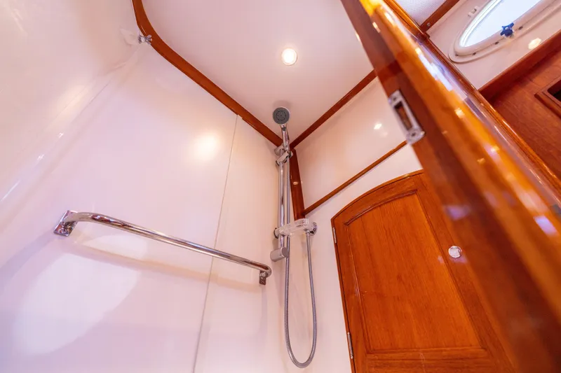 Barefoot Yacht Photos Pics Shower area in 2014 Hinckley Talaria 48 Flybridge yacht with wooden accents and chrome fixtures.
