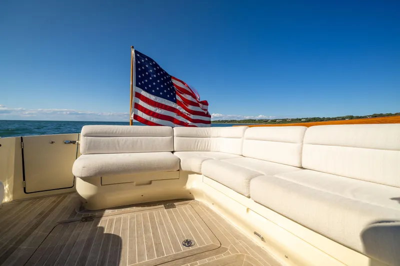 Barefoot Yacht Photos Pics Hinckley Talaria 48 Flybridge 2014 yacht deck with American flag and white seating.