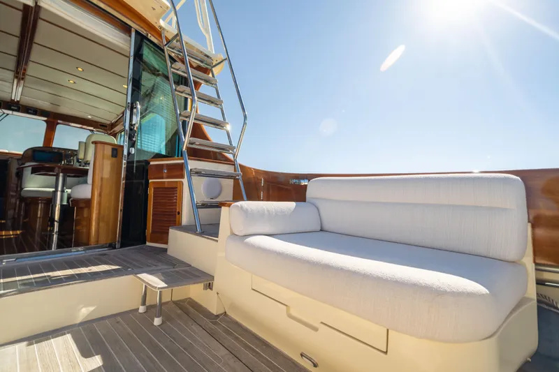 Barefoot Yacht Photos Pics 2014 Hinckley Talaria 48 Flybridge yacht with sunlit deck and elegant seating.