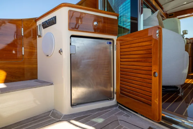 Barefoot Yacht Photos Pics Hinckley Talaria 48 Flybridge 2014 yacht interior with wooden cabinetry and stainless steel fridge.