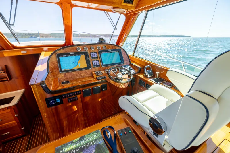 Barefoot Yacht Photos Pics 2014 Hinckley Talaria 48 Flybridge helm with navigation screens and luxurious seating.