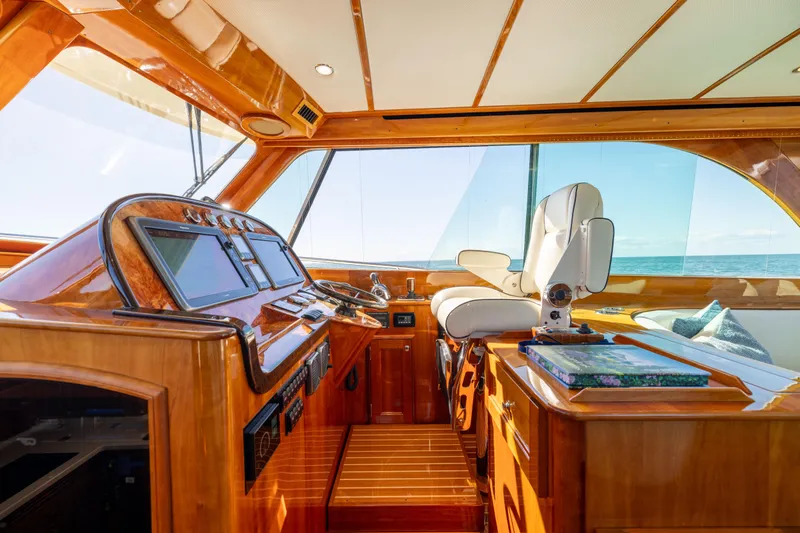 Barefoot Yacht Photos Pics 2014 Hinckley Talaria 48 Flybridge helm with luxurious wood finish and modern navigation equipment.
