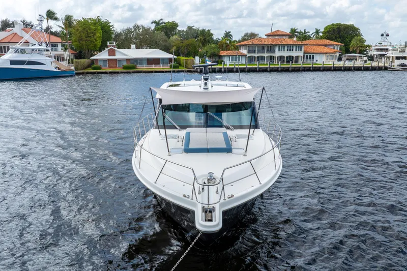 Sapphire Yacht Photos Pics 2022 Riviera 575 SUV yacht docked in a scenic waterfront setting.