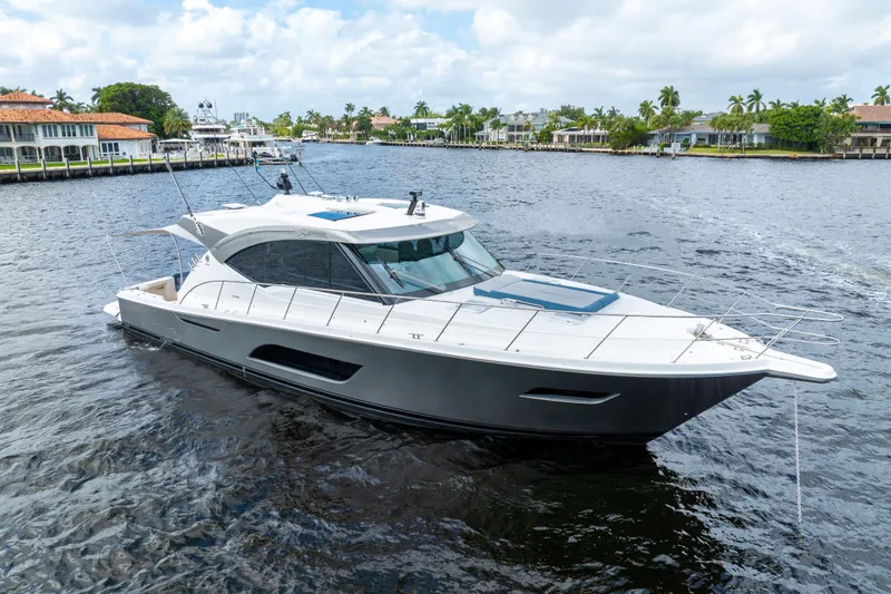 Sapphire Yacht Photos Pics 2022 Riviera 575 SUV yacht cruising on a scenic waterfront.
