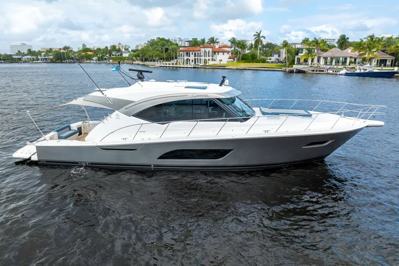 Sapphire Yacht Photos Pics 2022 Riviera 575 SUV yacht on calm water, showcasing sleek design and luxury features.