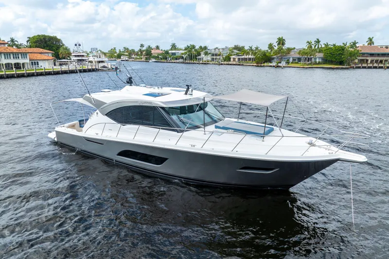 Sapphire Yacht Photos Pics 2022 Riviera 575 SUV luxury yacht cruising on a scenic waterway.