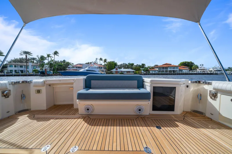 Sapphire Yacht Photos Pics 2022 Riviera 575 SUV yacht deck with seating, overlooking waterfront homes and clear blue sky.
