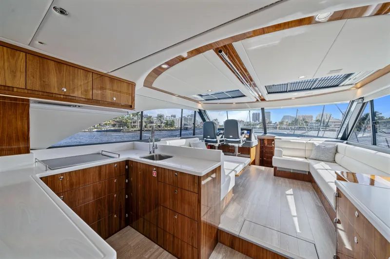 Sapphire Yacht Photos Pics Luxurious interior of 2022 Riviera 575 SUV yacht with modern wood finishes and panoramic windows.