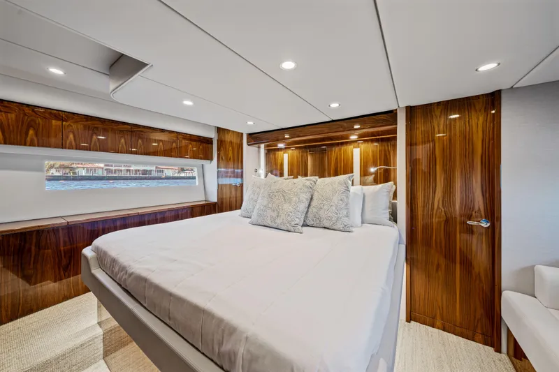 Sapphire Yacht Photos Pics Luxurious bedroom interior of 2022 Riviera 575 SUV yacht with elegant wood finishes.