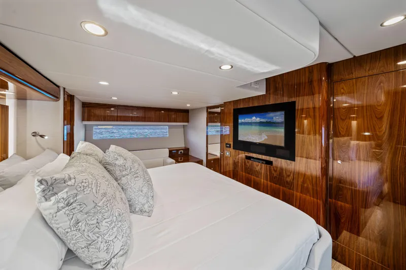 Sapphire Yacht Photos Pics Luxurious 2022 Riviera 575 SUV bedroom with elegant wood paneling and modern amenities.