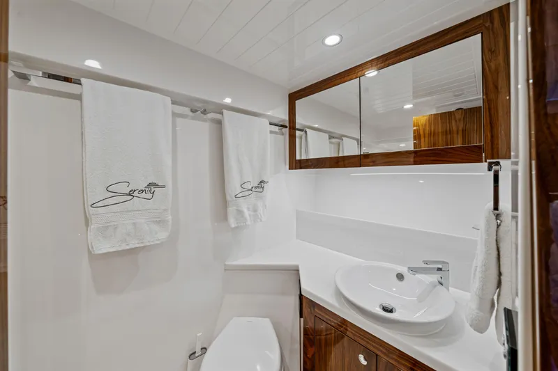 Sapphire Yacht Photos Pics Luxurious bathroom in 2022 Riviera 575 SUV yacht with elegant wood accents and modern fixtures.