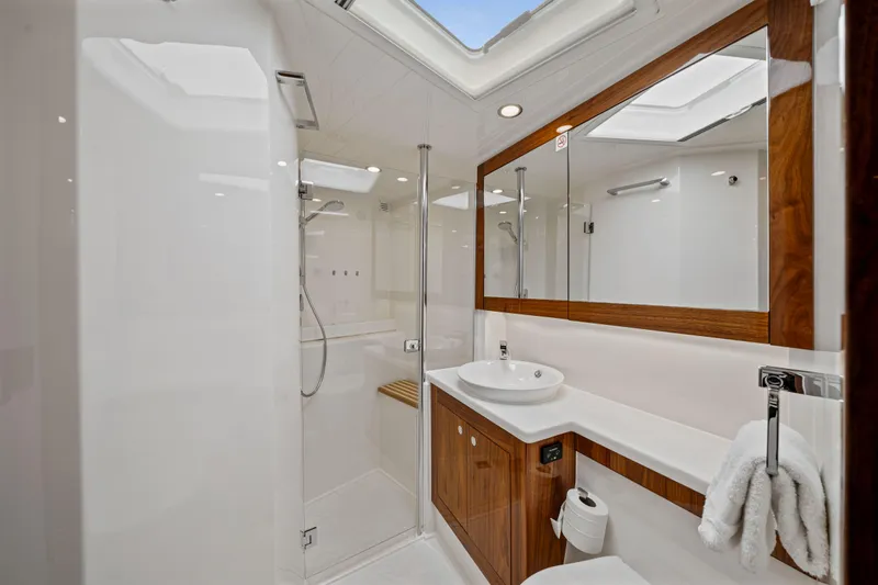 Sapphire Yacht Photos Pics Luxurious bathroom interior of 2022 Riviera 575 SUV yacht with modern fixtures and wood accents.